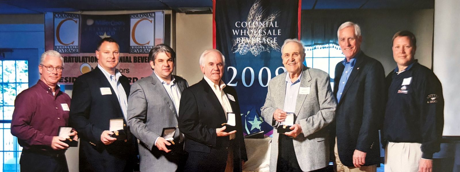 7 Men Holding Awards and Smiling
