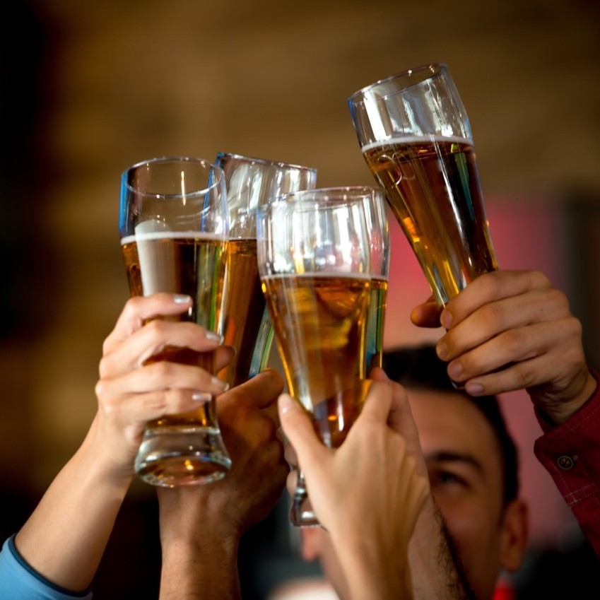 Four people holding up beer glasses